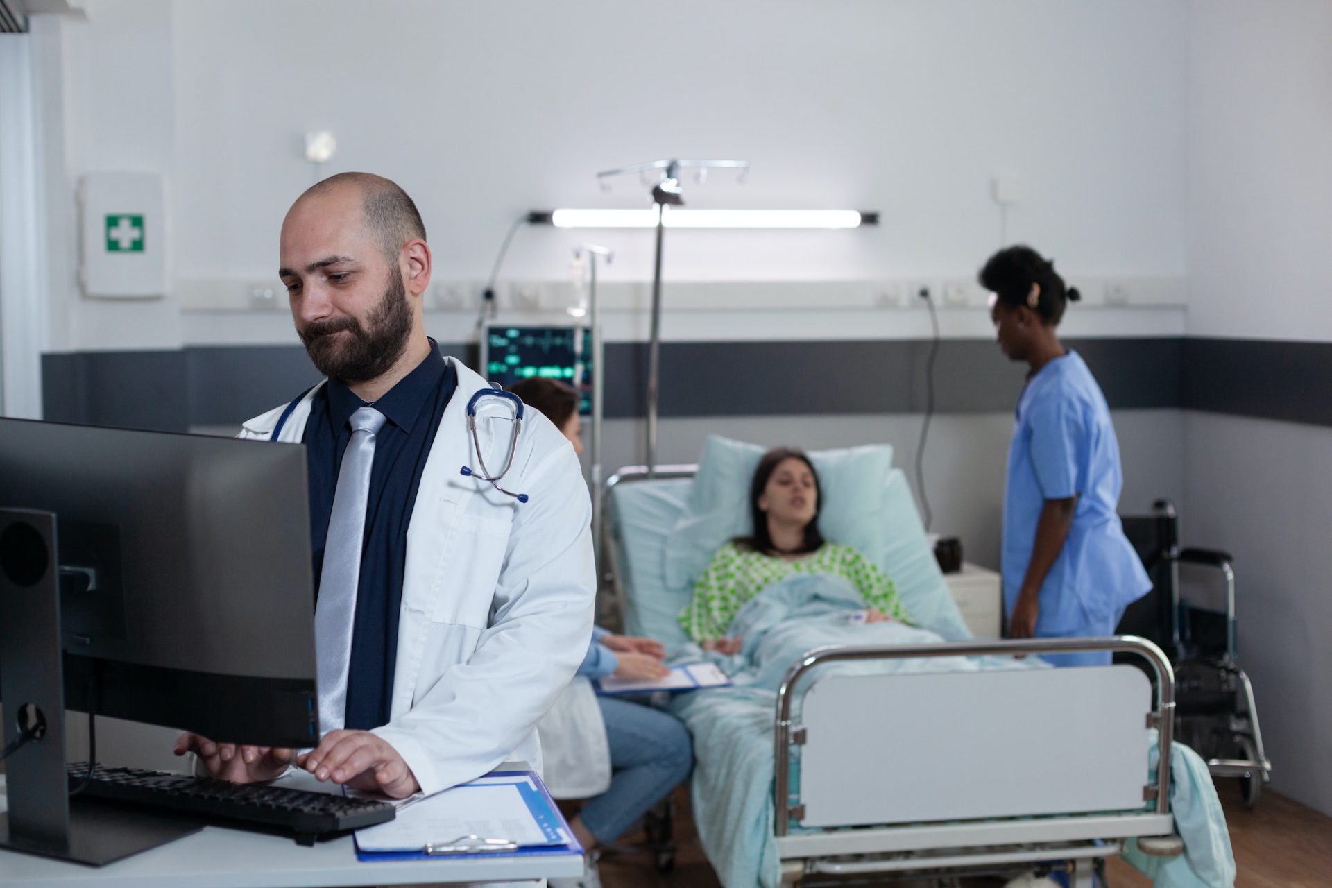 Medical doctor using personal computer to complete patient admission chart